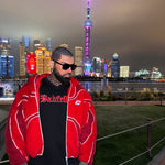 Person wearing a red jacket with a city skyline in the background