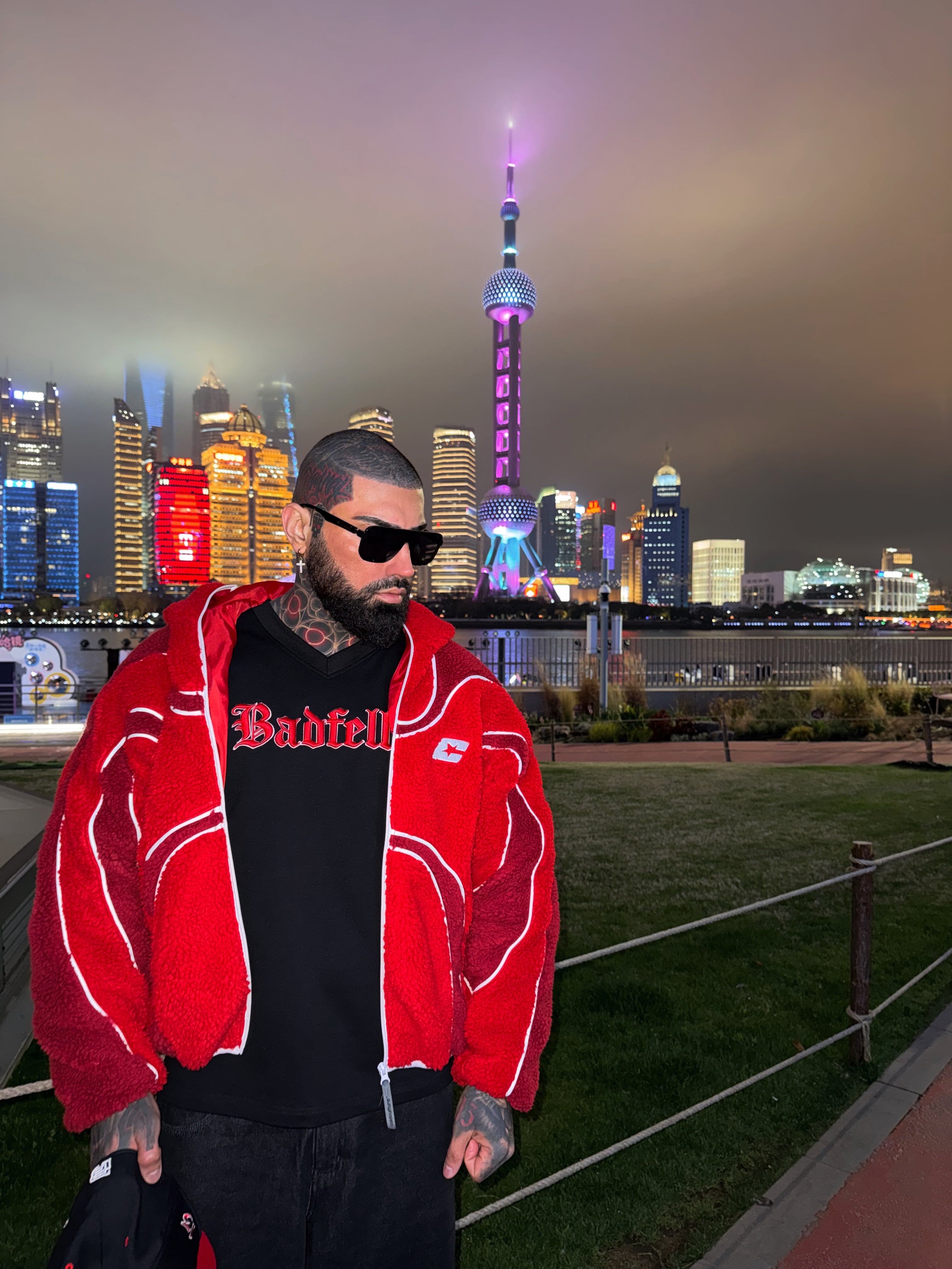 Person wearing a red jacket with a city skyline in the background