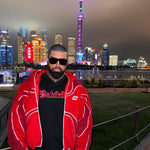 Person wearing a red jacket with a city skyline in the background