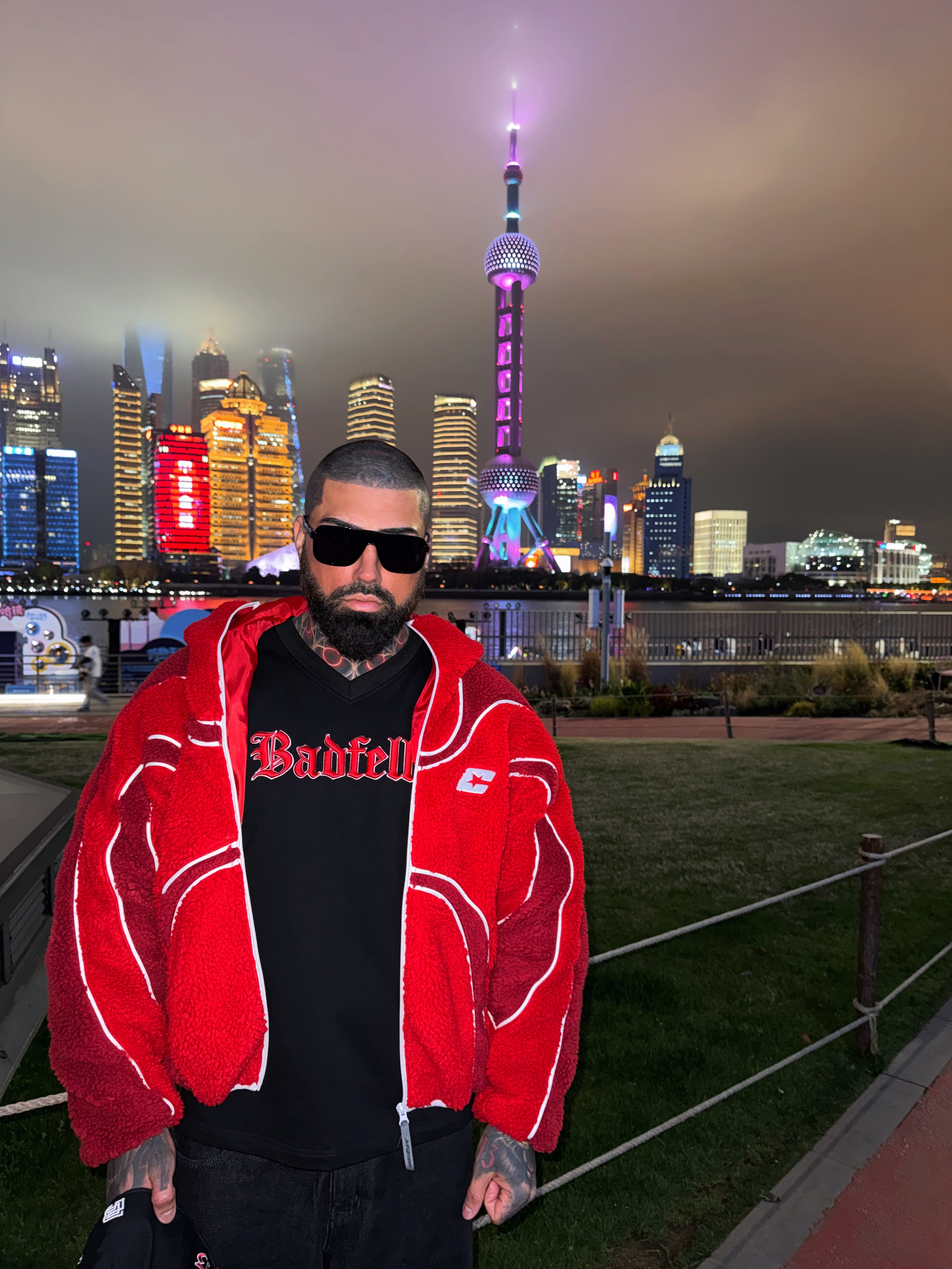 Person wearing a red jacket with a city skyline in the background