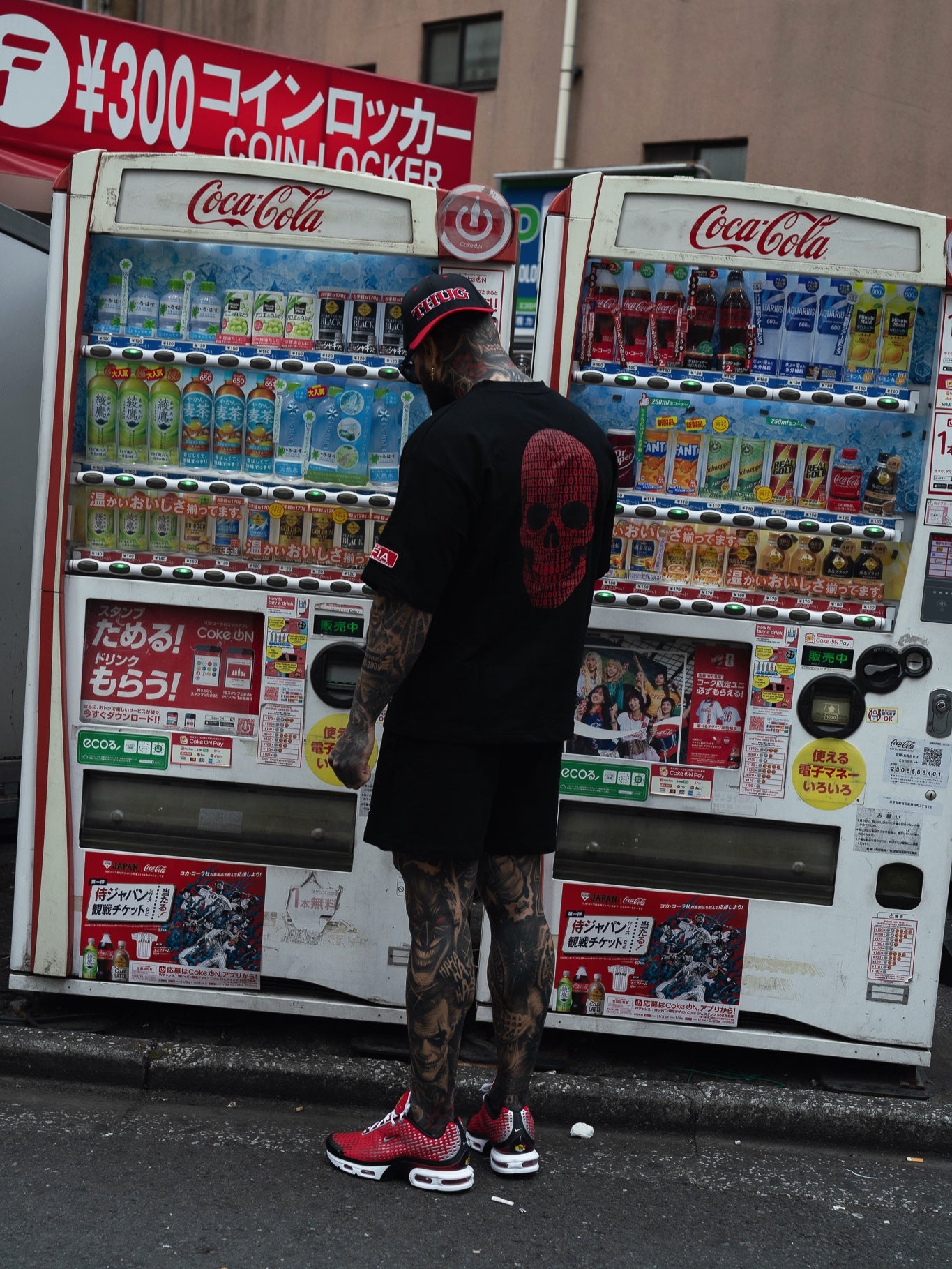 Person interacting with a Coca-Cola vending machine in an urban setting